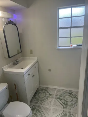 a bathroom with a sink mirror vanity and toilet