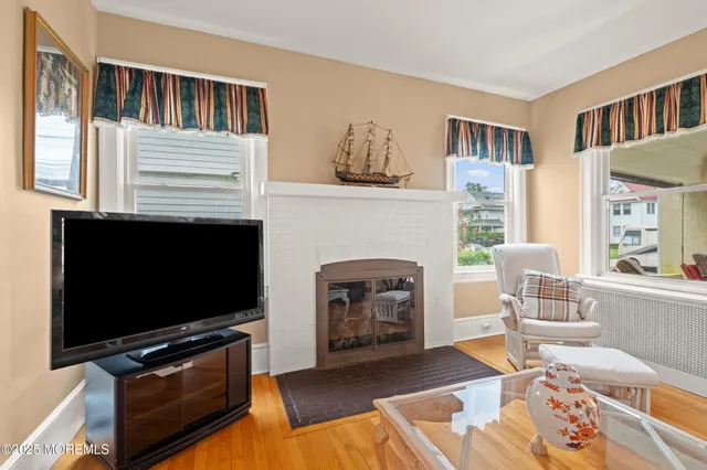 a living room with furniture a flat screen tv and a fireplace