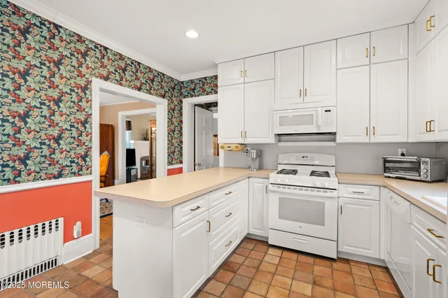 a kitchen with white cabinets and white appliances