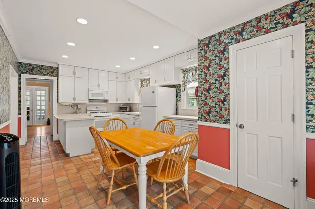 a view of a dining room with furniture and kitchen view