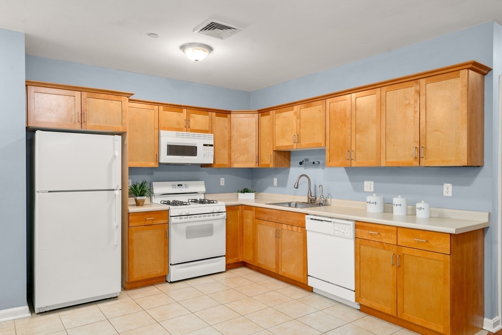 327 Centre Street, Unit 308 Boston, MA 02130 - Photo 4 of 13 a kitchen with a sink appliances cabinets and a window