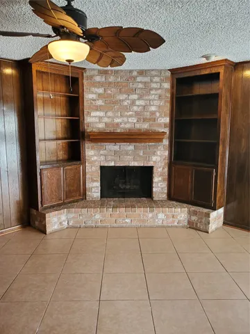 a view of an empty room with a fireplace and a cabinet