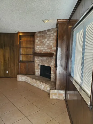 a view of fireplace and window in an empty room