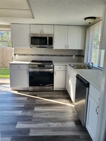 a kitchen with granite countertop a stove and a sink
