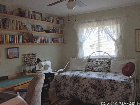 232 North Ridgewood Avenue, Unit A5 Edgewater, FL 32132 - Photo 12 of 15 a bedroom with a bed a window and book shelf