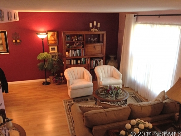 232 North Ridgewood Avenue, Unit A5 Edgewater, FL 32132 - Photo 2 of 15 a living room with furniture a lamp and a potted plant