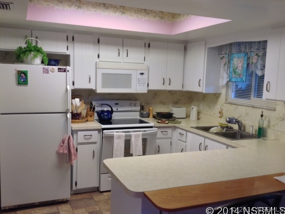 232 North Ridgewood Avenue, Unit A5 Edgewater, FL 32132 - Photo 6 of 15 a kitchen with stainless steel appliances granite countertop a sink stove and refrigerator