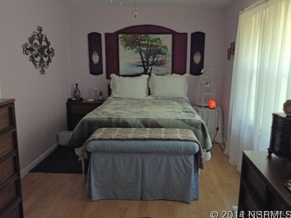 232 North Ridgewood Avenue, Unit A5 Edgewater, FL 32132 - Photo 9 of 15 a bedroom with a bed and window