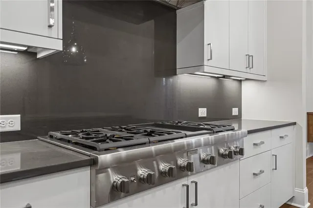 a view of a room with wooden floor and kitchen view