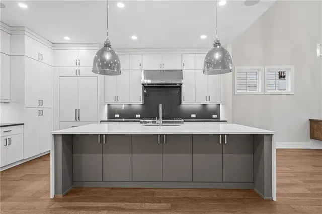 a kitchen with stainless steel appliances granite countertop a sink a stove and a refrigerator