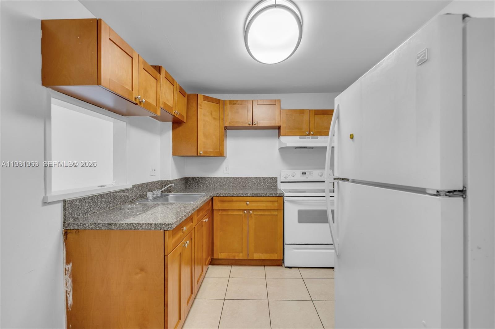 9143 Southwest 77th Avenue, Unit B710 Miami, FL 33156 - Photo 7 of 28 a kitchen with a refrigerator a stove top oven and a sink
