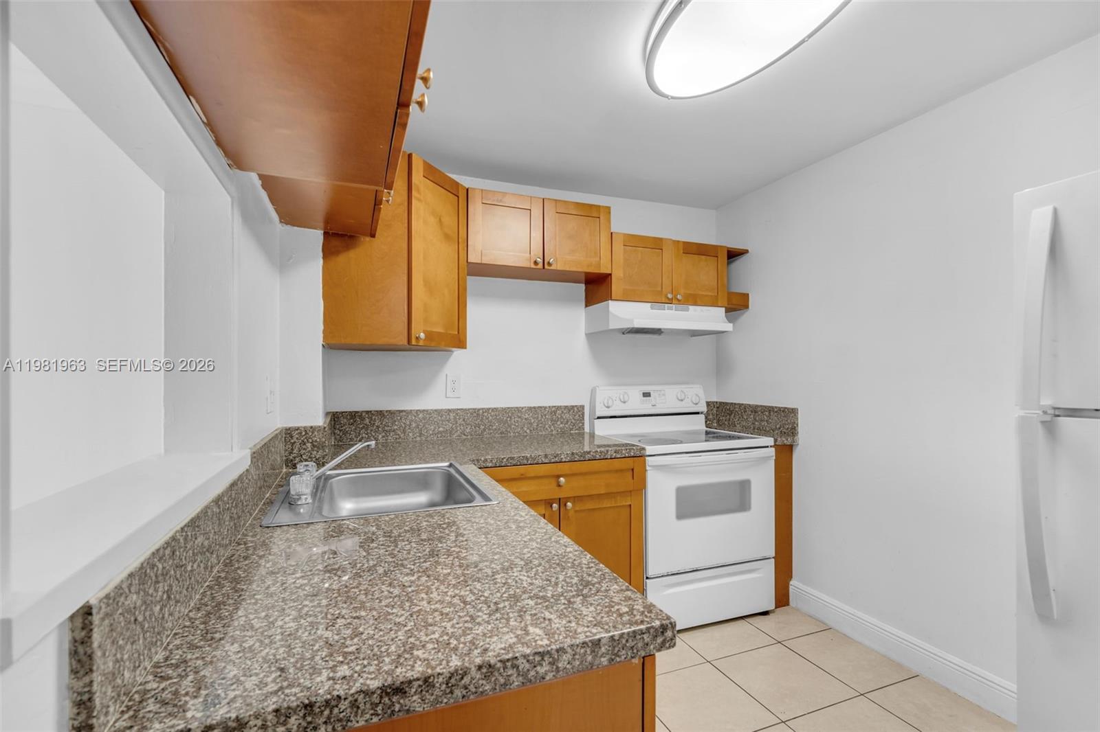 9143 Southwest 77th Avenue, Unit B710 Miami, FL 33156 - Photo 8 of 28 a kitchen with a sink stove and microwave