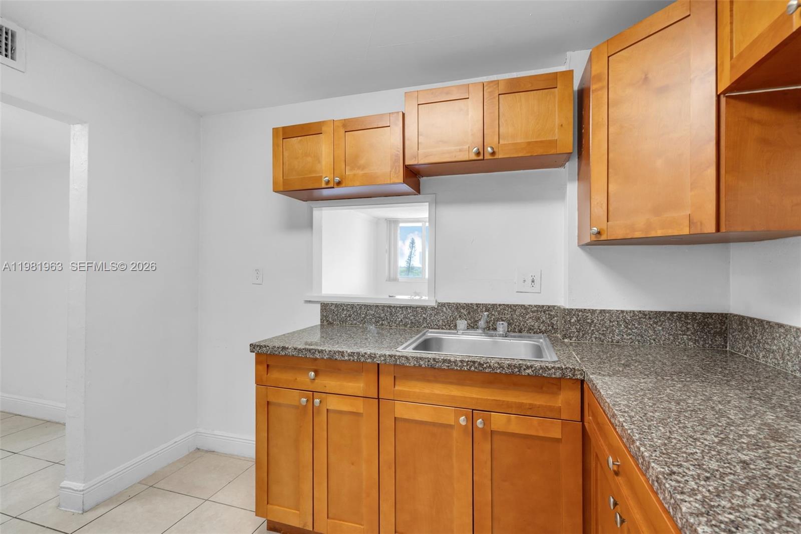9143 Southwest 77th Avenue, Unit B710 Miami, FL 33156 - Photo 9 of 28 a kitchen with stainless steel appliances granite countertop a sink and a cabinets