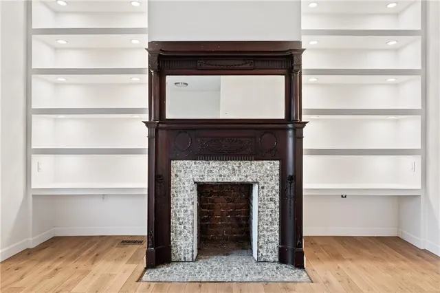 a living room with a wooden floor and a fireplace