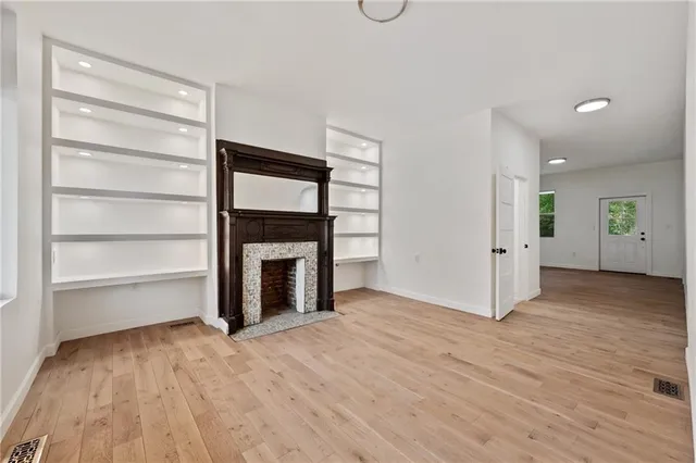 a view of an empty room with a fireplace and a window