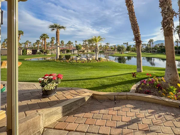 a view of swimming pool with a table and chairs in the patio