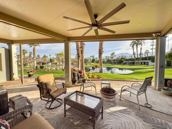 a view of a patio with a table chairs and a backyard