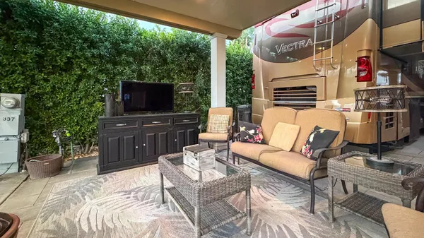 a outdoor living space with furniture and a flat screen tv
