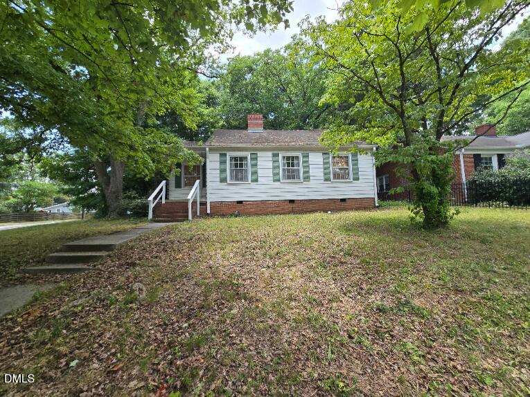 a front view of a house with a yard and trees
