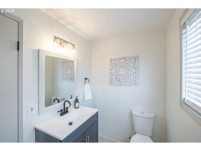 a bathroom with a sink mirror and a toilet