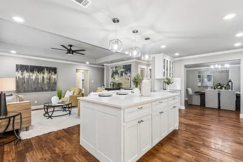 a large white kitchen with cabinets