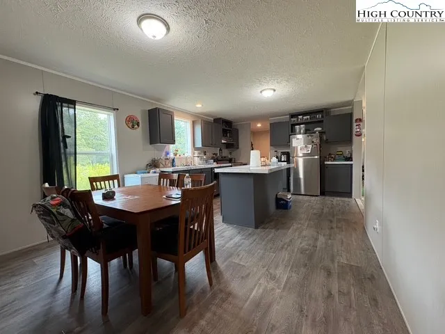 a kitchen with a table chairs wooden cabinets and stainless steel appliances