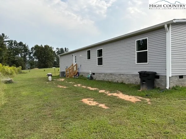 a backyard of a house with yard table and chairs