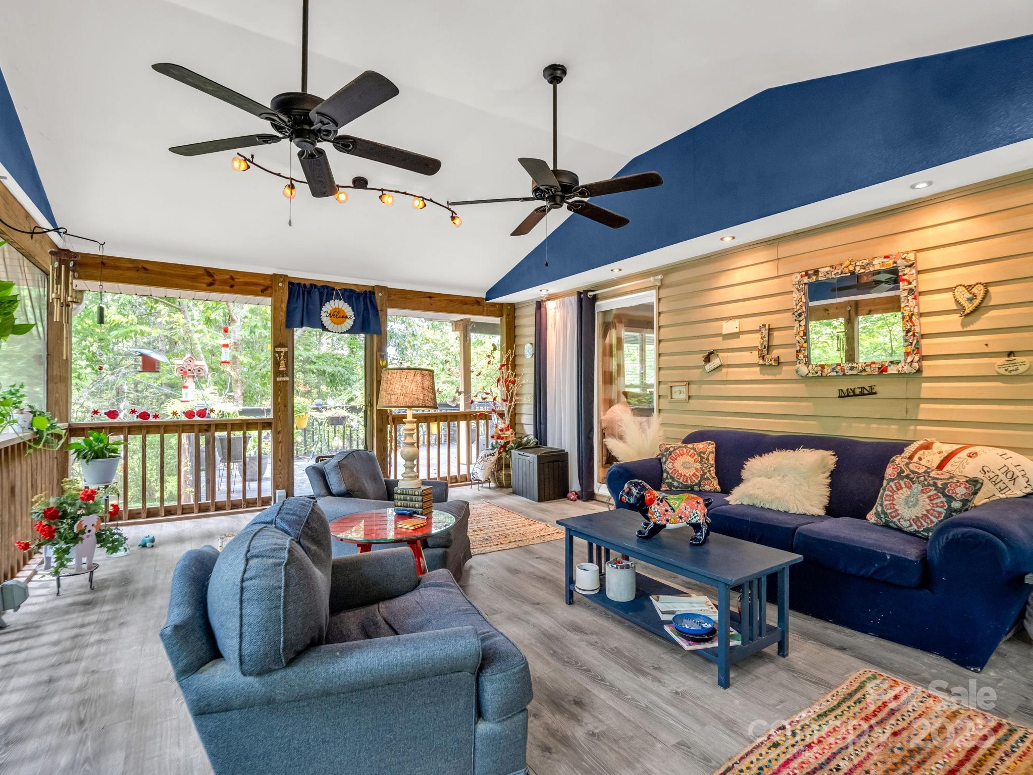 134 Downing Place Lake Lure, NC 28746 - Photo 24 of 35 a living room with furniture ceiling fan and a large window