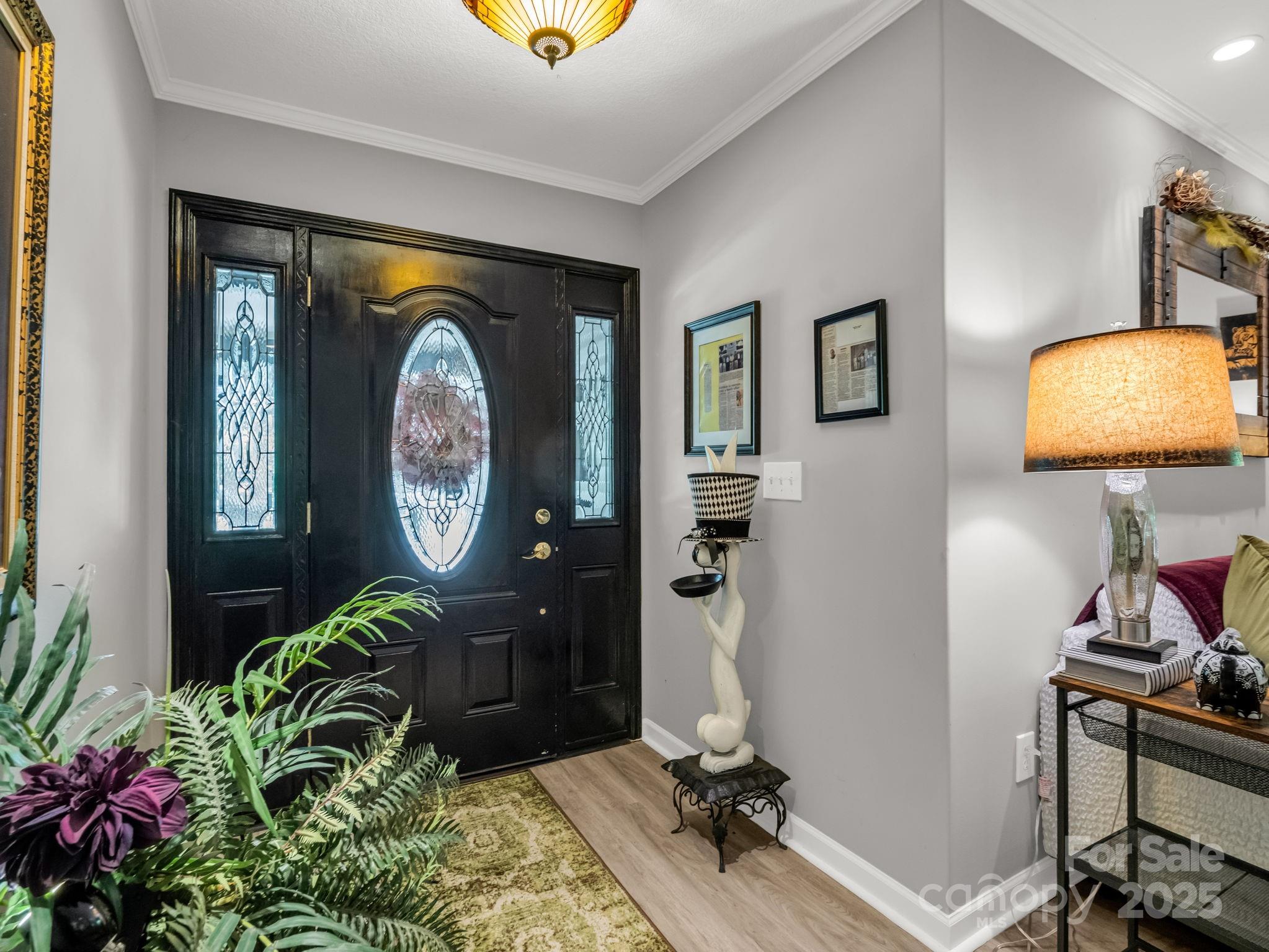 134 Downing Place Lake Lure, NC 28746 - Photo 3 of 35 a living room with painting on the wall and a potted plant