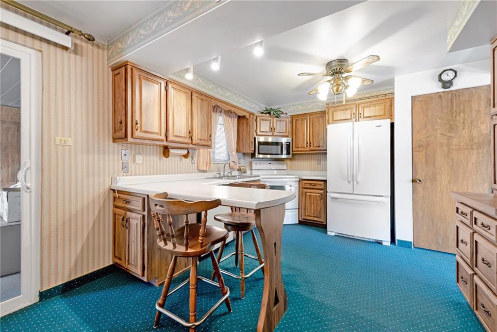 709 Indian Hill Road Rostraver Township, PA 15012 - Photo 16 of 25 a kitchen with stainless steel appliances granite countertop a refrigerator a sink dishwasher a stove and white countertops with wooden floor