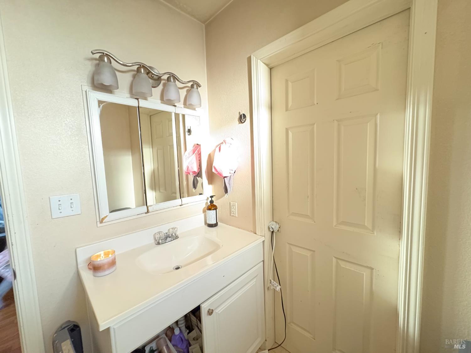 313 Roney Avenue Vallejo, CA 94590 - Photo 25 of 26 a bathroom with a sink vanity and a mirror