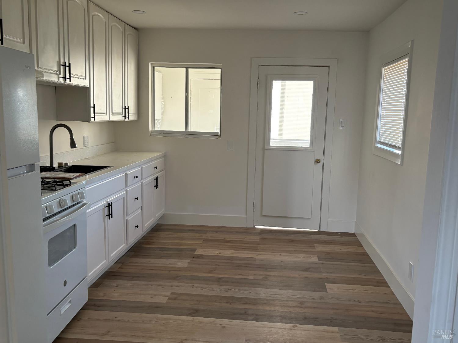 313 Roney Avenue Vallejo, CA 94590 - Photo 6 of 26 a kitchen with granite countertop white cabinets and white appliances
