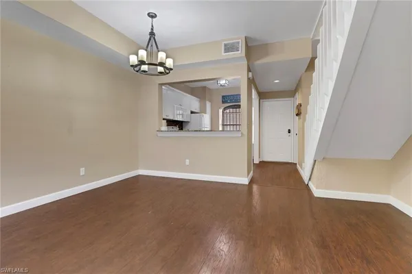 a view of a room with wooden floor chandelier and entryway