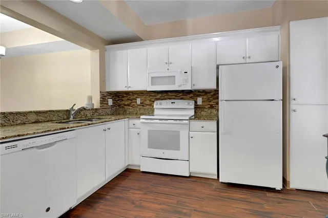 a kitchen with white cabinets and white appliances