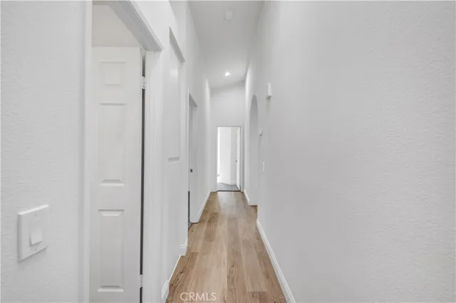 a view of a hallway with wooden floor and closet