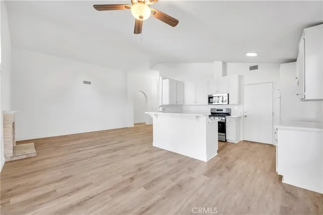 a view of kitchen with stainless steel appliances refrigerator stove microwave and cabinets