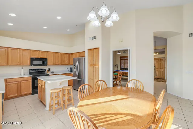 a kitchen with stainless steel appliances granite countertop a sink a stove a refrigerator cabinets and living room view