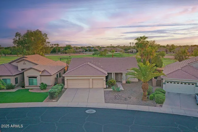 an aerial view of residential houses with outdoor space and trees