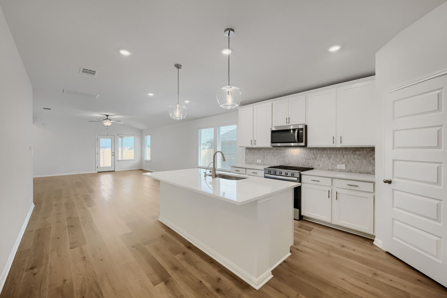 146 Diablo Rim Terrace Dripping Springs, TX 78620 - Photo 13 of 32 A well-lit kitchen with a central island seamlessly flows into an open living area, ideal for gathering.