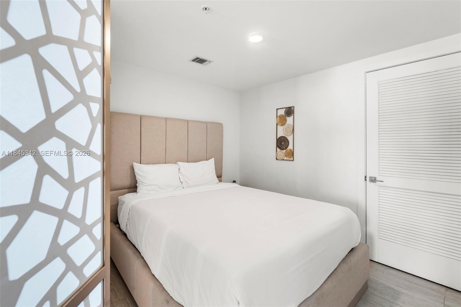 3900 Biscayne Boulevard, Unit S400 Miami, FL 33137 - Photo 21 of 50 a large bed sitting in a bedroom next to a window