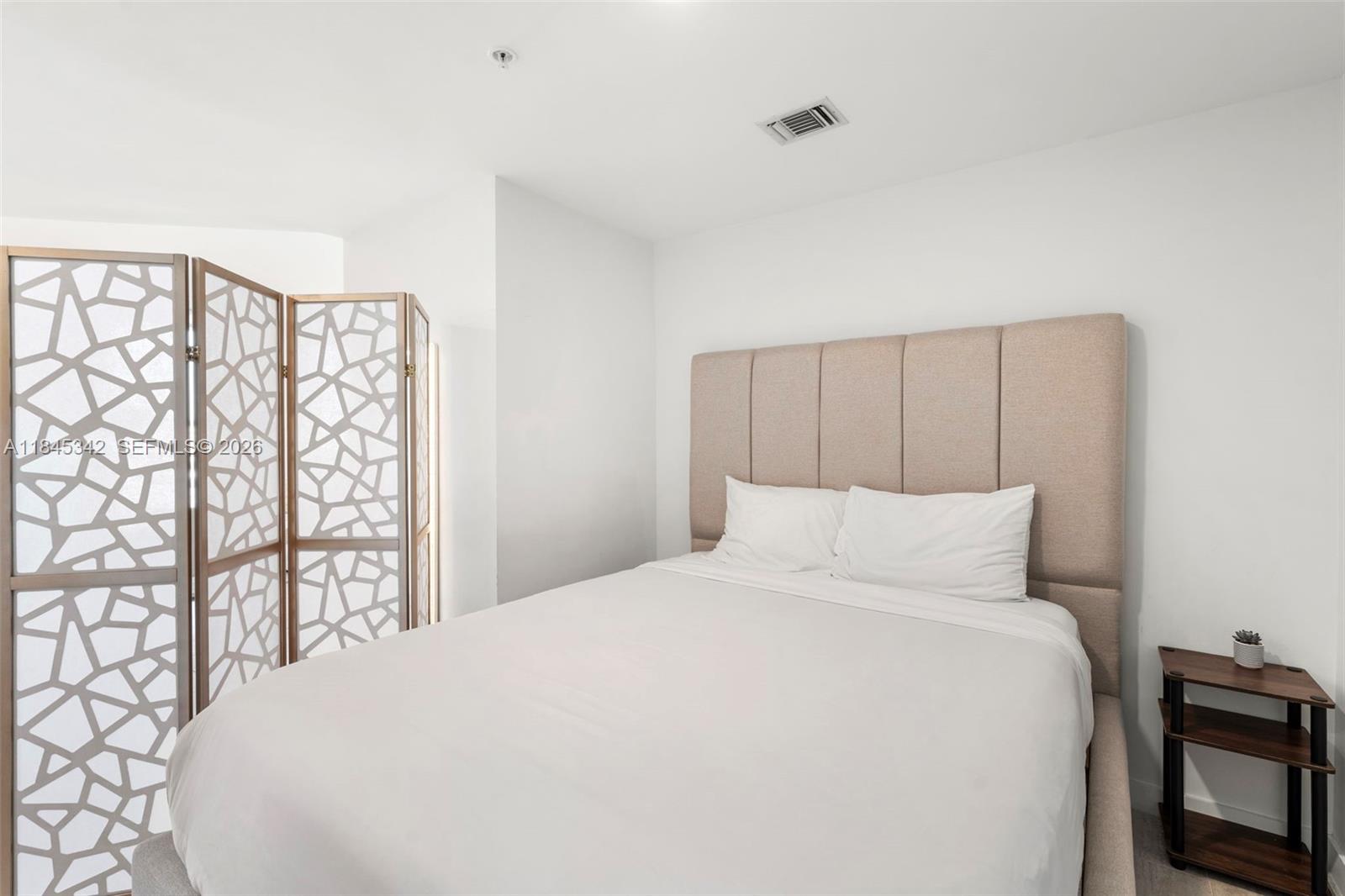 3900 Biscayne Boulevard, Unit S400 Miami, FL 33137 - Photo 22 of 50 a large bed sitting in a bedroom next to a window