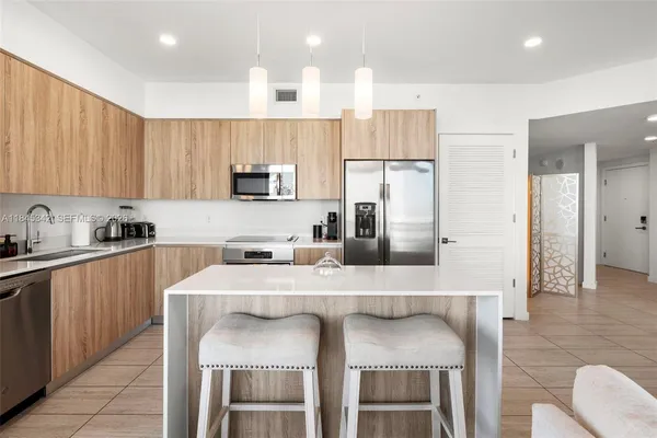 a kitchen with stainless steel appliances granite countertop a refrigerator stove and sink