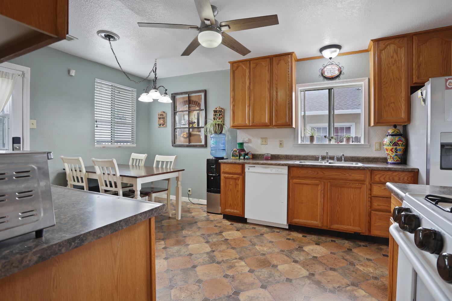 513 Harold Street Lodi, CA 95240 - Photo 17 of 29 a kitchen with a stove a sink a dining table and chairs