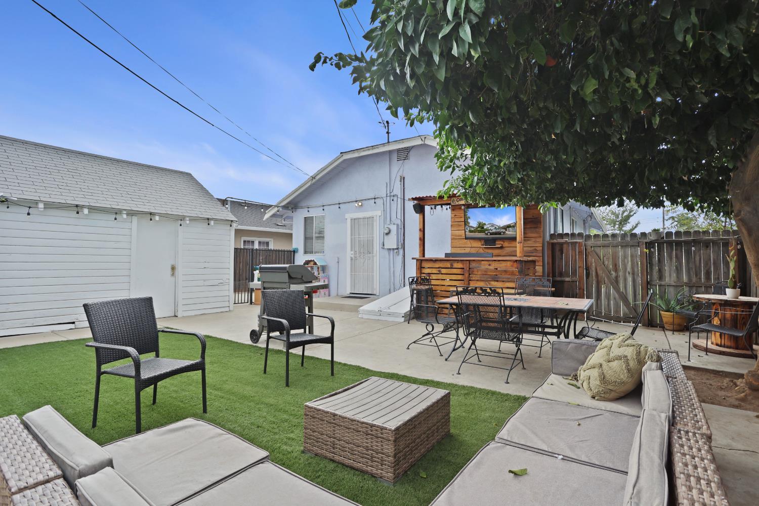 513 Harold Street Lodi, CA 95240 - Photo 24 of 29 a view of a patio with table and chairs potted plants and a large tree