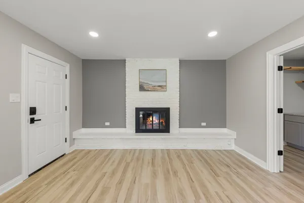 a view of a livingroom with wooden floor and a fireplace