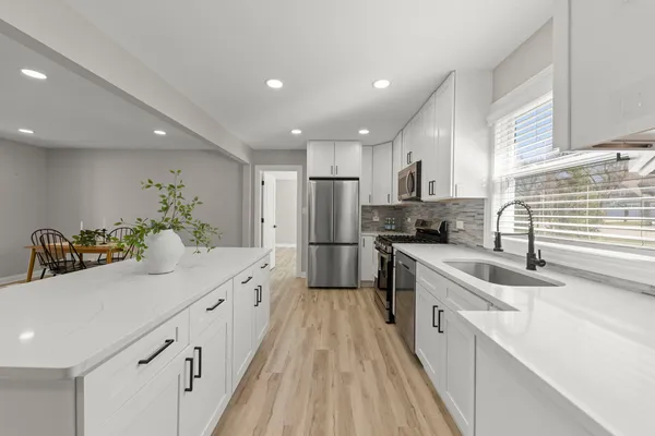 a kitchen with stainless steel appliances kitchen island granite countertop a sink and cabinets