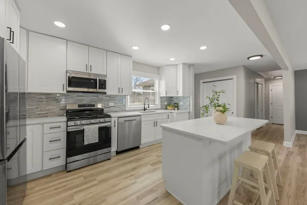a kitchen with sink a microwave and cabinets