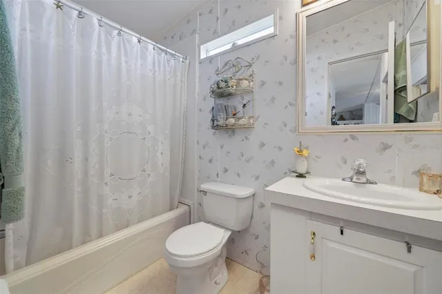 a view of a backyard with table and chairs and a large tree