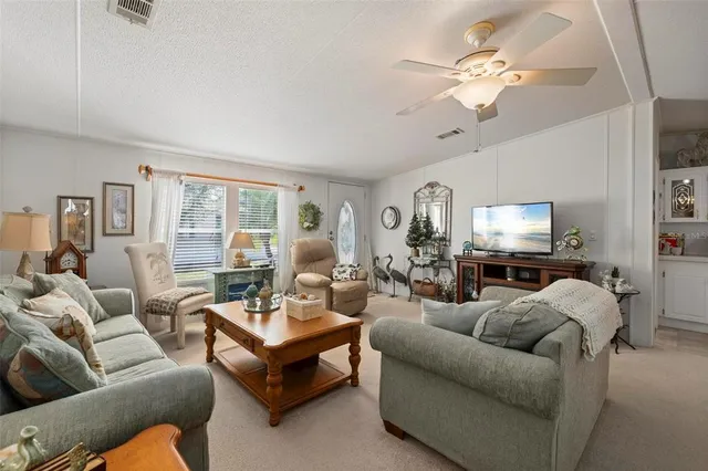 a living room with furniture a flat screen tv and a window