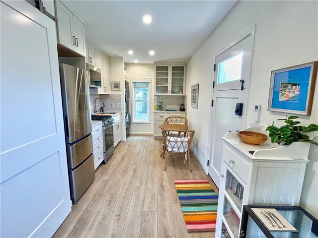 a room with stainless steel appliances furniture and a rug
